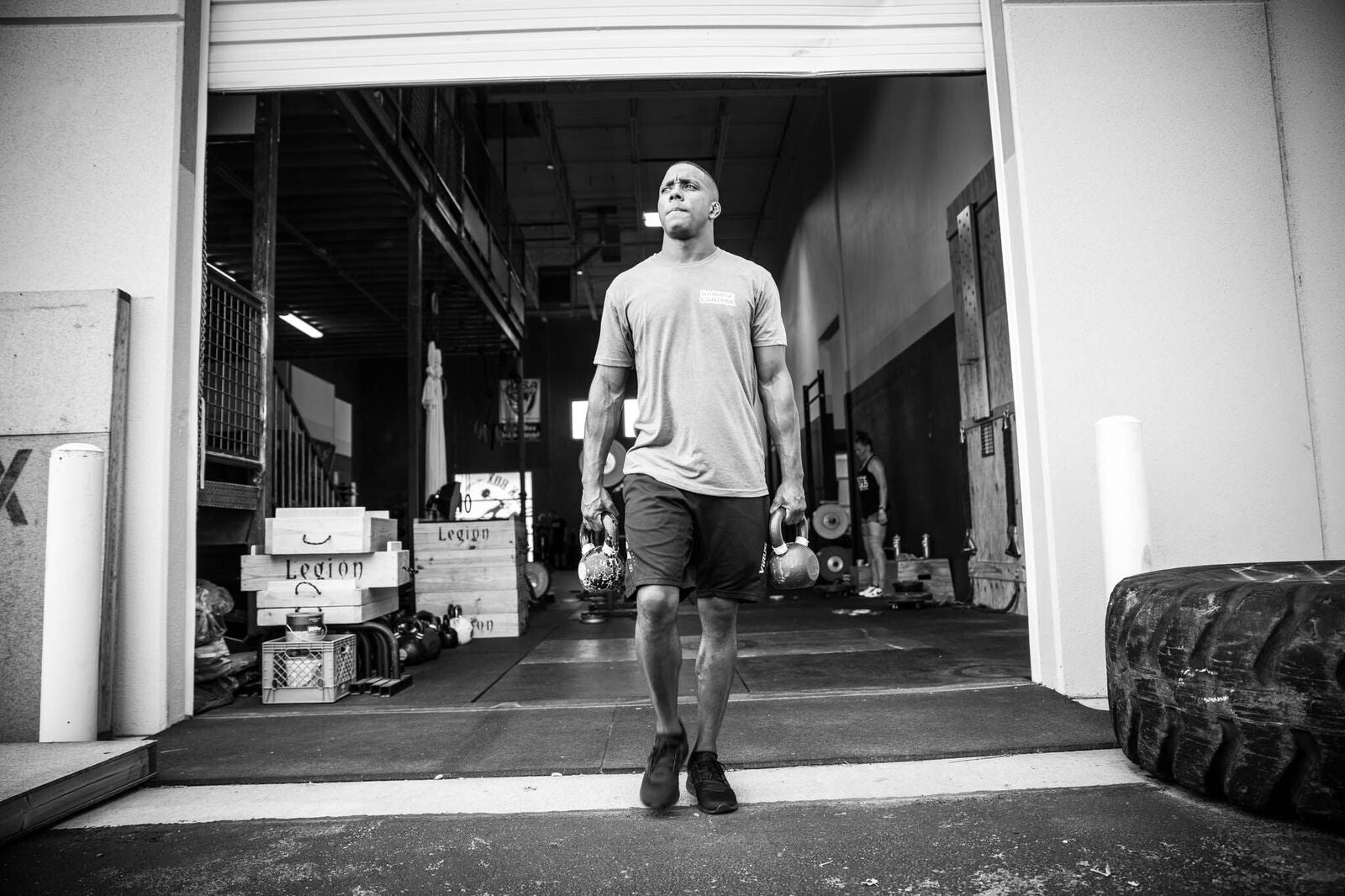 Man carrying kettlebells outside a gym