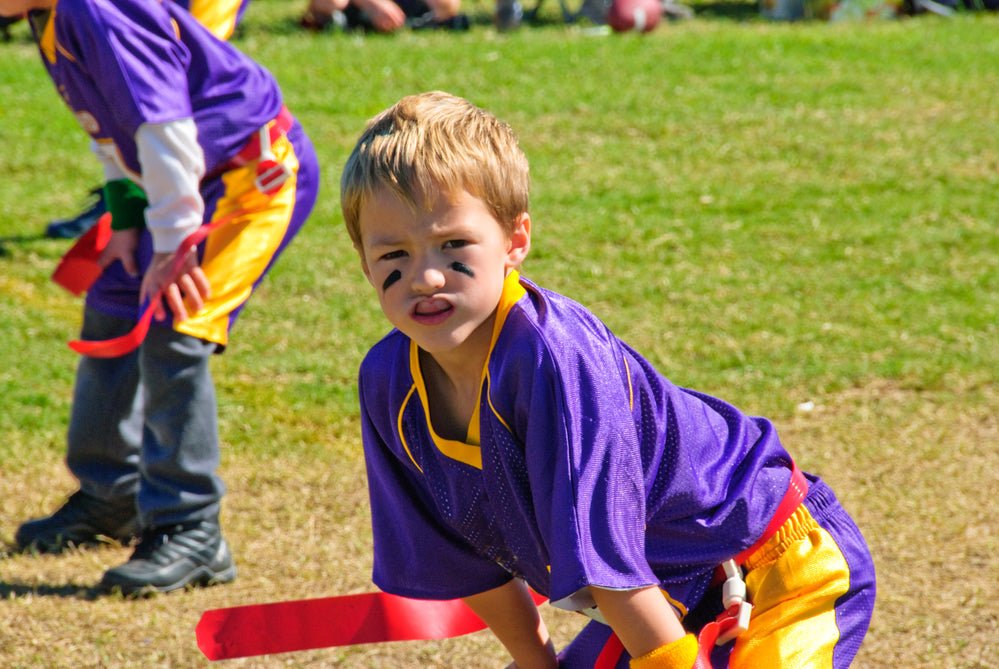 Boy in purple jersey playing flag football